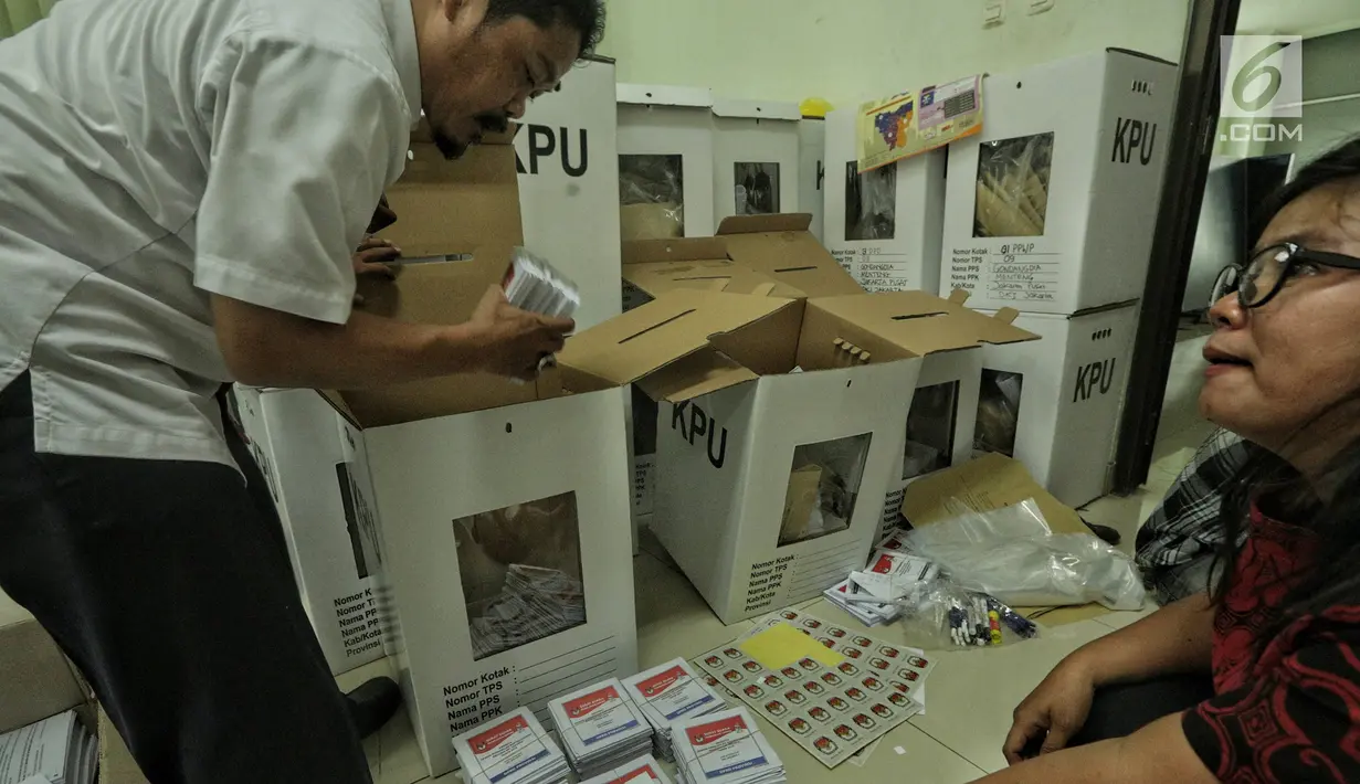 Petugas memasukkan logistik Pemilu 2019 ke kotak suara saat proses persiapan distribusi di Kecamatan Menteng, Jakarta, Senin (15/4). Proses pendistribusian ke tps masing-masing kelurahan diperkirakan akan tuntas sehari sebelum hari pencoblosan pada 17 April 2019. (Liputan6.com/Faizal Fanani)