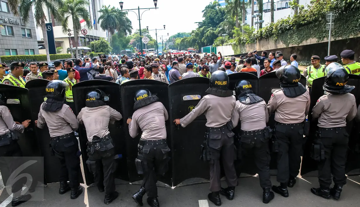 Polisi anti huru hara menjaga aksi ratusan orang Papua yang berdomisili di Jawa dan Bali saat memperingati 1 Desember di Bundaran HI, Jakarta, Selasa (1/12). Tanggal 1 Desember juga diartikan sebagai hari kemerdekaan Papua. (Liputan6.com/Faizal Fanani)