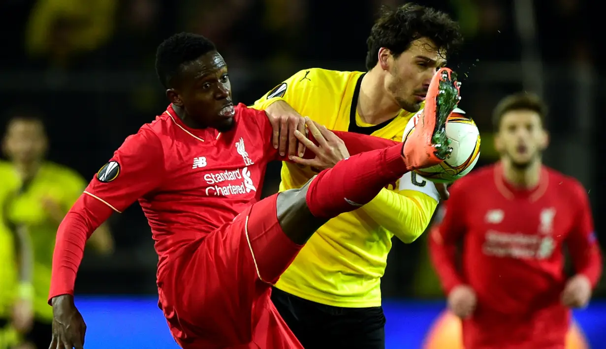 Duel antara pemain Dortmund, Mats Hummels, dan pemain Liverpool, Divock Origi, pada laga leg pertama perempat final Liga Europa di Stadion Signal Iduna Park, Dortmund, Jumat (8/4/2016) dini hari WIB. (AFP/John Macdougall)