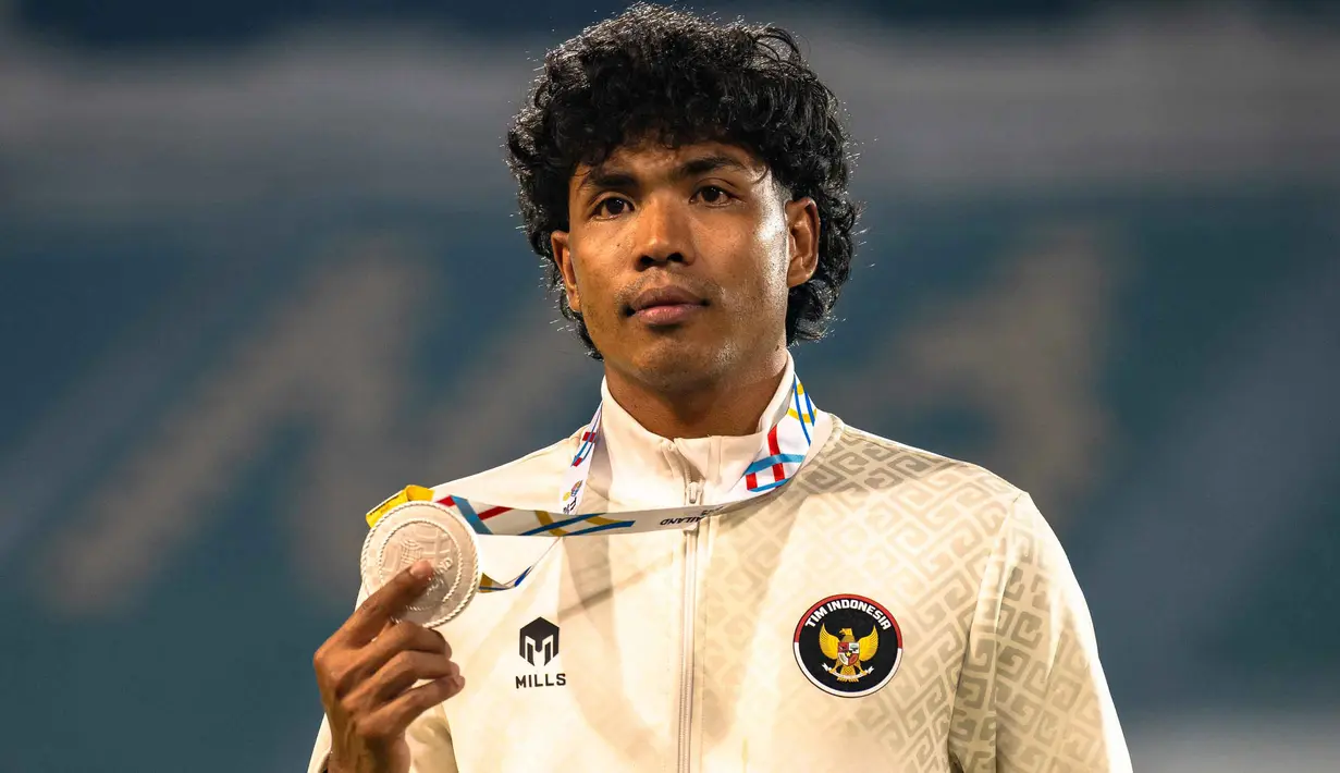 Di final, Lalu Muhammad Zohri tampil dengan kecepatan stabil sejak start hingga garis finis. Tampak dalam foto, Lalu Muhammad Zohri berpose untuk foto dengan medali peraknya setelah meraih posisi kedua di final lari 100 meter putra cabang atletik pada SEA Games ke-33 di Suphachalasai National Stadium, Bangkok, pada Kamis 11 Desember 2025. (Chanakarn LAOSARAKHAM/AFP)