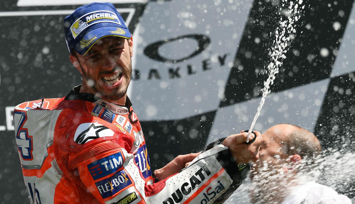 Pebalap Ducati, Andrea Dovizioso, merayakan keberhasilannya meraih gelar juara balapan MotoGP Italia di Sirkuit Mugello, Minggu (4/6/2017). Dovizioso menjadi yang tercepat dengan waktu 41 menit 32,126 detik.(AFP/Vincenzo Pinto)