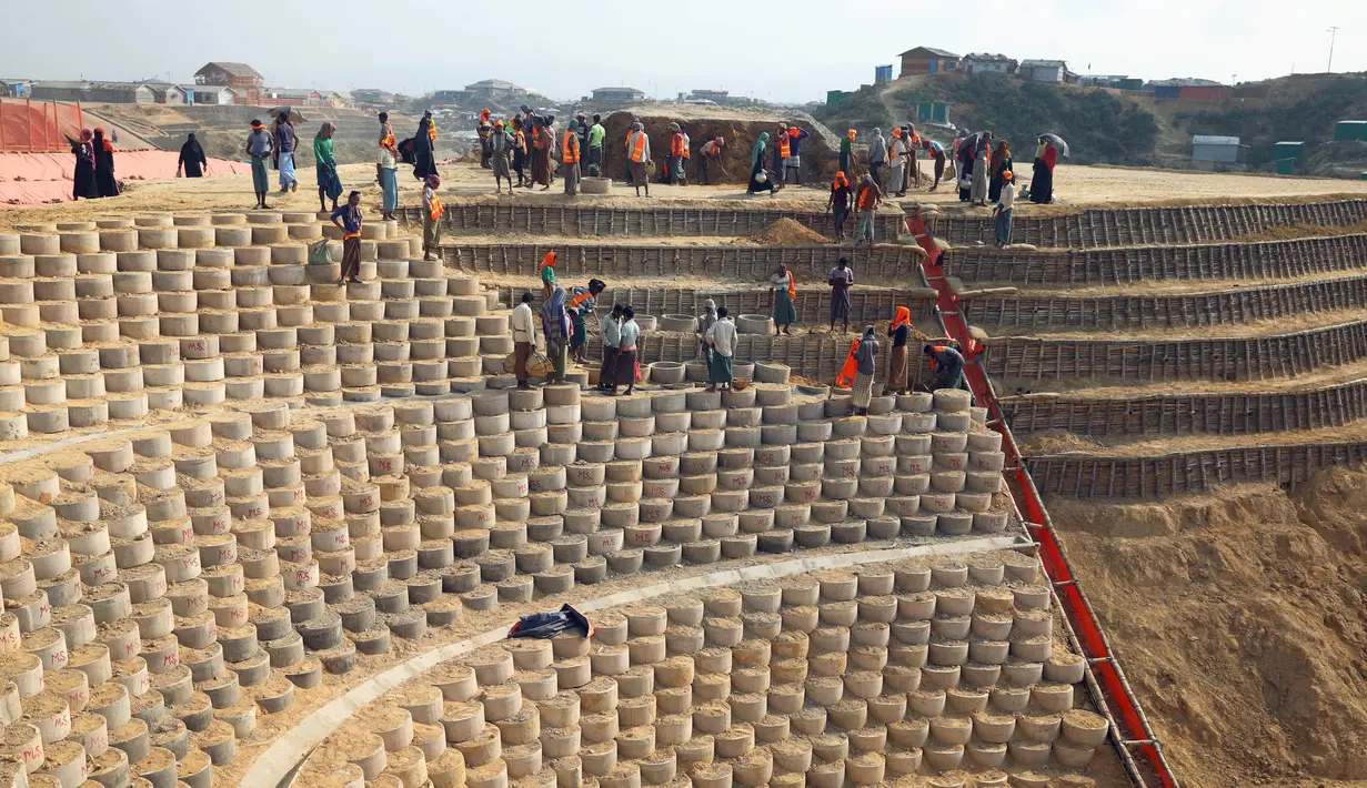 Pengungsi Rohingya membangun bendungan untuk mencegah tanah longsor jelang musim hujan di kamp pengungsi di Cox's Bazar, Bangladesh (8/4). Sekitar 740 ribu warga Rohingya melarikan diri dari Myanmar ke Bangladesh menyusul operasi militer Myanmar Agustus 2017 silam. (Reuters/Mohammad Ponir Hossain)