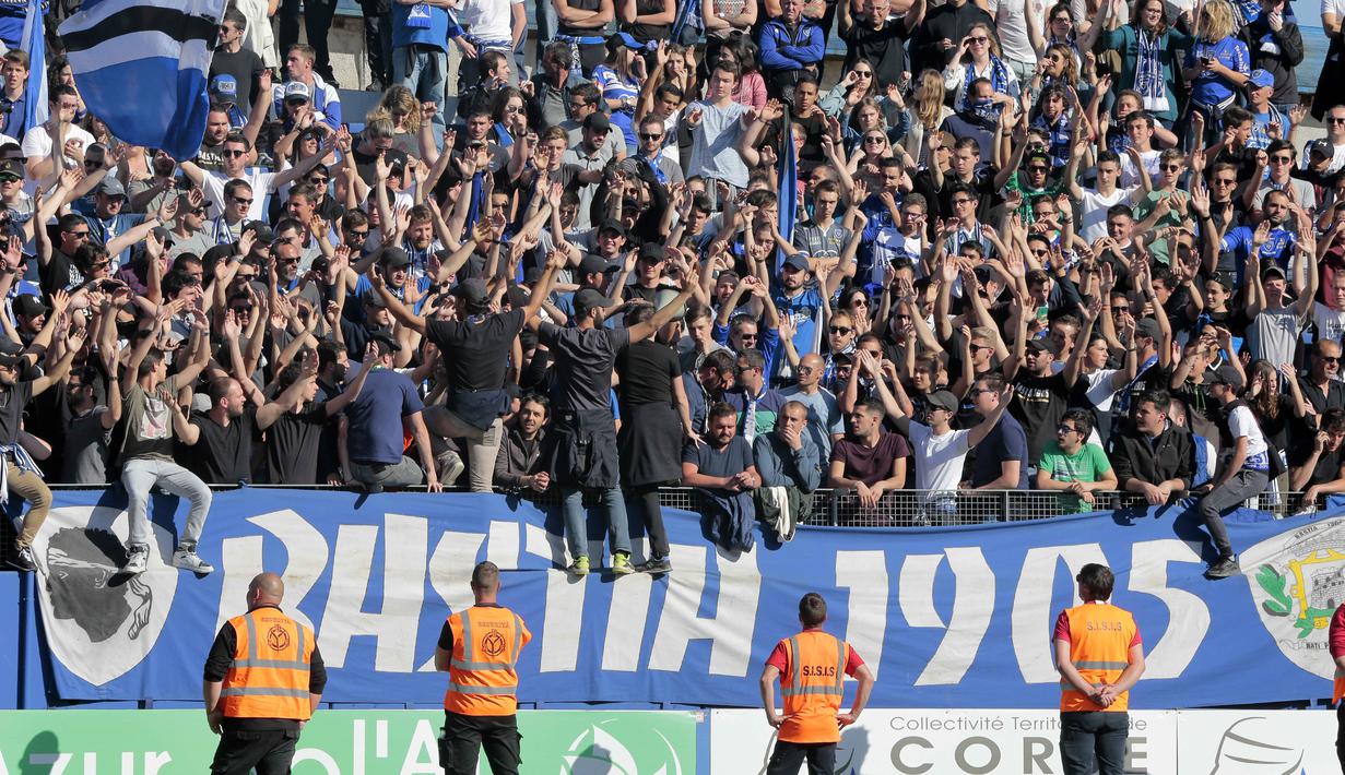 Aksi Suporter Bastia, Grup 1905 saat mendukung timnya berlaga melawan Lyon pada lanjutan Ligue 1 Prancis di Armand Cesari stadium, Bastia, (16/4/2017). Laga ini akhirnya dihentikan LFP. (AFP/Pascal Pochard-Casabianca)
