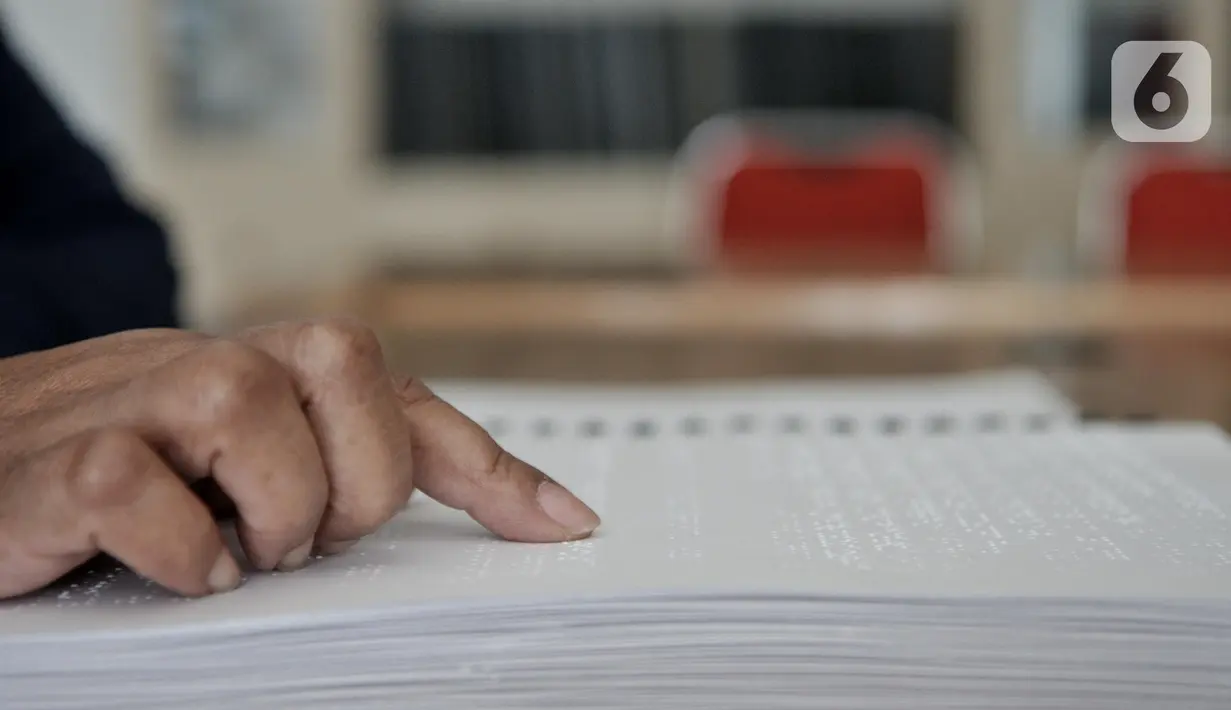 Penyandang tunanetra meraba huruf braille saat membaca buku di Perpustakaan Yayasan Mitra Netra, Jakarta, Selasa (3/12/2019). Perpustakaan Mitra Netra menyajikan buku-buku khusus penyandang tunanetra, seperti buku braille, buku audio digital, dan buku elektronik. (merdeka.com/Iqbal S Nugroho)