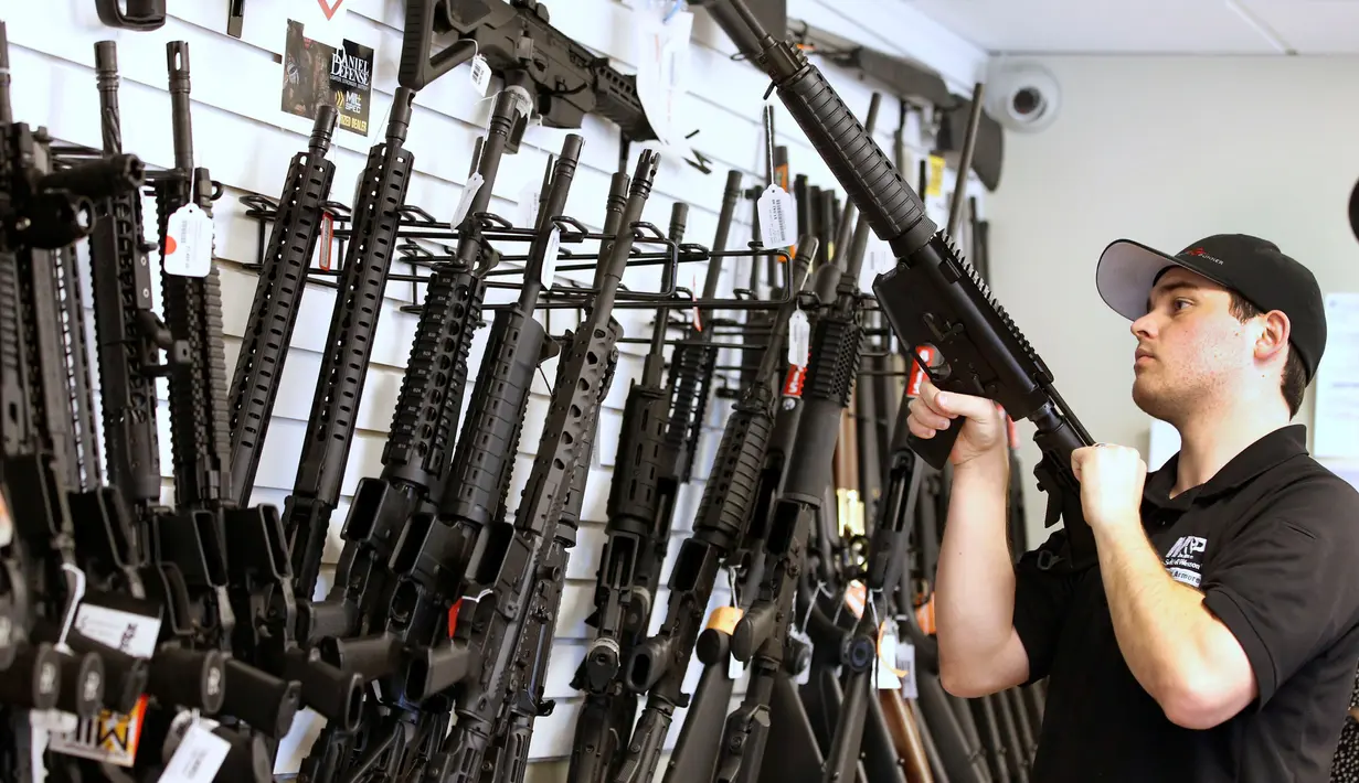 Penjaga toko Ryan Martinez  saat merapikan barang dagangannya di toko senjata "Ready Gunner", Utah, AS, (21/6). Maraknya kasus penembakan yang baru saja terjadi di Orlando, pemerintah AS akan menerapkan pengendalian senjata api. (REUTERS / George Frey)