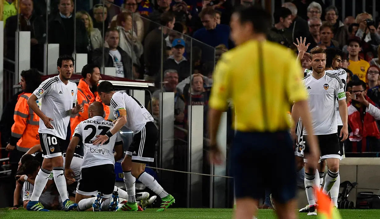 Para pemain Valencia melakukan selebrasi usai penyerang Valencia, Santi Mina membuat gol kegawang Barcelona di pertandingan liga Spanyol di Camp Nou stadium (18/4). Valencia menang atas Barcelona dengan skor 2-1. (AFP PHOTO/GENE Lluis)