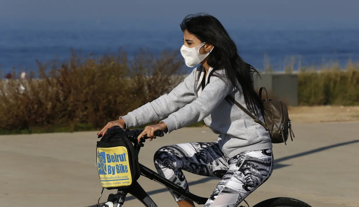 Seorang anak perempuan yang memakai masker menaiki sepeda di Beirut, ibu kota Lebanon (26/12/2020). Menteri Kesehatan Lebanon Hamad Hassan pada Jumat (25/12) mengumumkan bahwa seorang penumpang yang tiba di Beirut dari Inggris membawa varian baru COVID-19. (Xinhua/Bilal Jawich)