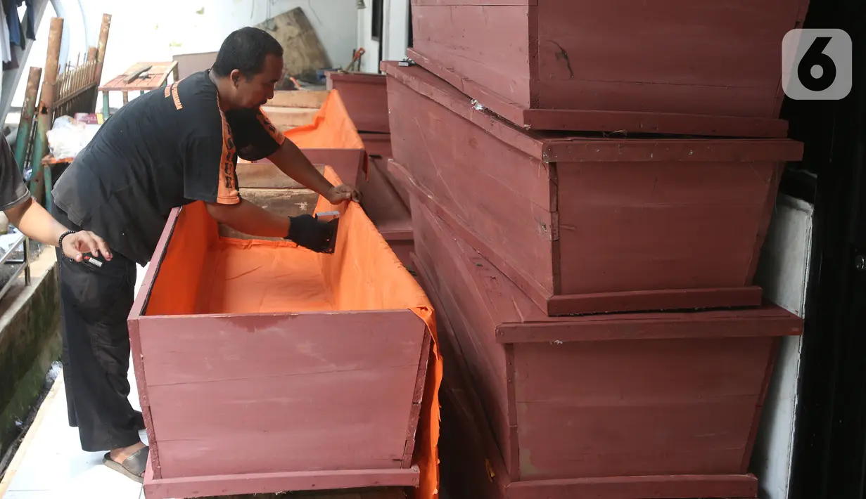 Proses pembuatan peti mati khusus jenazah virus corona atau Covid-19 di Dinas Pertamanan dan Pemakaman Jakarta, Sabtu (28/3/2020). Peti mati korban meninggal akibat corona Covid-19 itu dilapisi kantong jenazah dan kain kafan untuk mencegah penyebaran virus. (Liputan6.com/Angga Yuniar)
