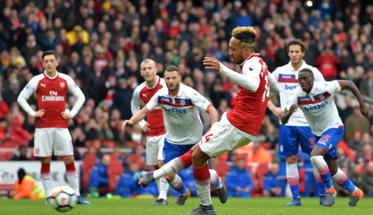 Striker Arsenal, Pierre-Emerick Aubameyang, melakukan eksekusi penalti saat melawan Stoke pada laga Premier league di Stadion Emirates, London, Minggu (1/4/2018). Arsenal menang 3-0 atas Stoke. (AFP/Oliver Greenwood)