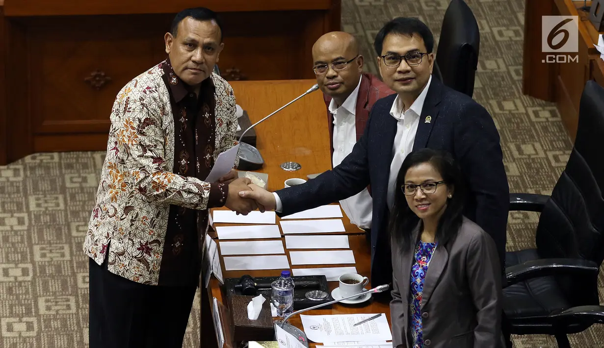 Calon Pimpinan KPK Irjen Firli Bahuri (kiri) berjabat tangan dengan Ketua Komisi III DPR Aziz Syamsuddin (kanan) usai menerima amplop berisi tema makalah yang harus dibuat, saat uji kelayakan dan kepatutan capim KPK di Kompleks Parlemen, Senayan, Jakarta, Senin (9/9/2019). (Liputan6.com/Johan Tallo)