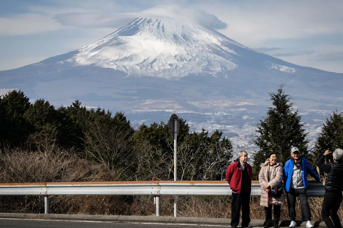 Orang-orang sedang berfoto di depan Gunung Fuji Jepang di kota Gotemba, prefektur Shizuoka. Yuichi YAMAZAKI / AFP