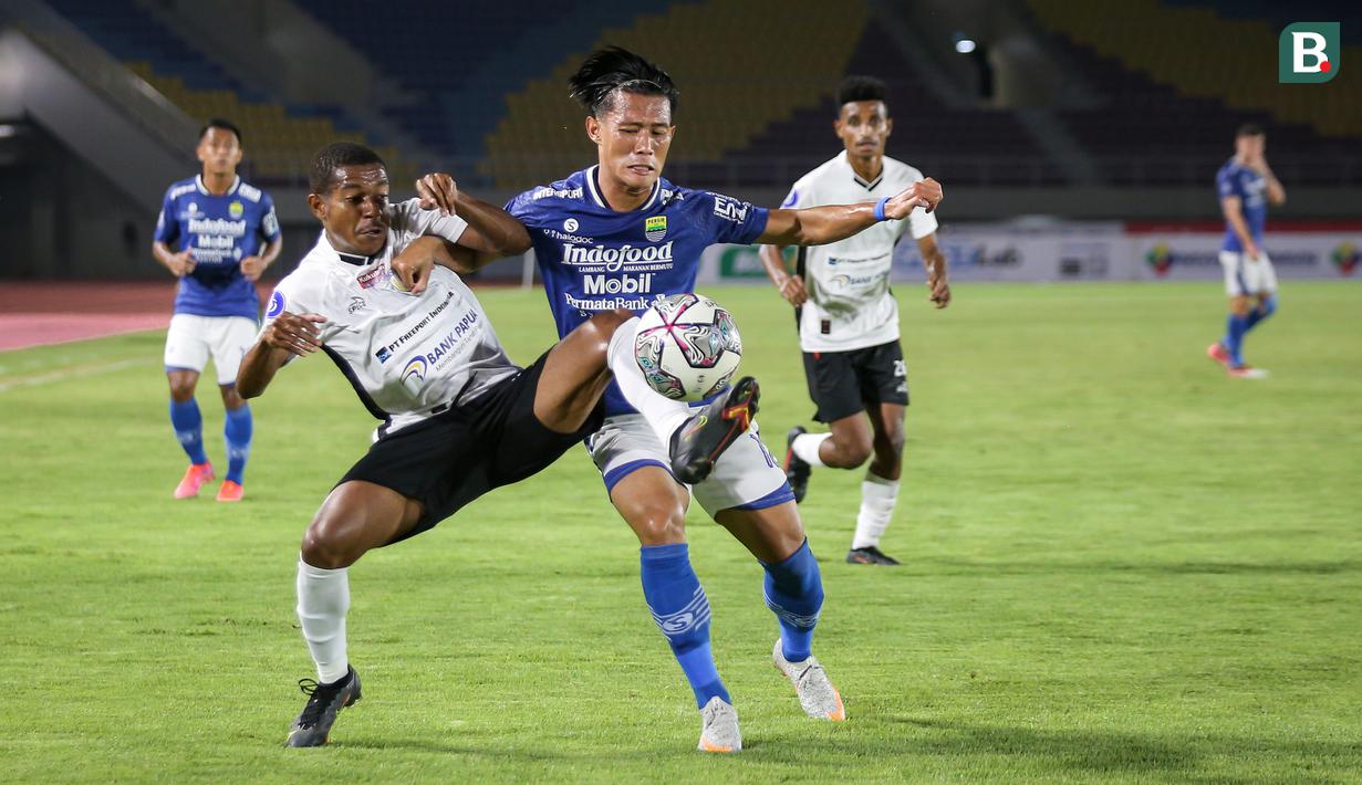 Pemain Persib Bandung, Henhen Herdiana (kanan) berebut bola dengan pemain Persipura Jayapura, Juscak Joshua Marthen Isir dalam laga pekan ke-10 BRI Liga 1 2021/2022 di Stadion Manahan, Solo, Sabtu (30/10/2021). (Bola.com/Bagaskara Lazuardi)
