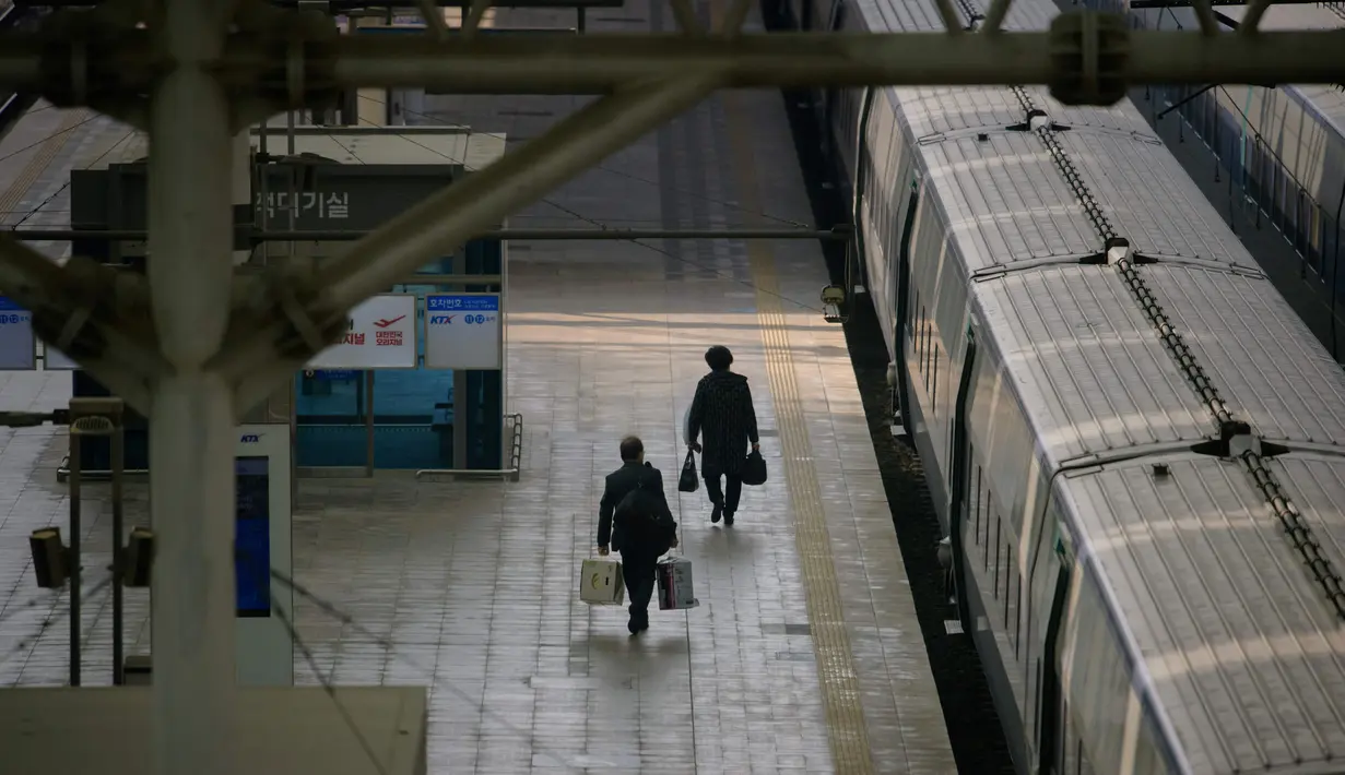 Penumpang berjalan di peron stasiun Seoul untuk menaiki kereta menjelang liburan Tahun Baru Imlek di Korea Sealatan, Rabu (10/2/2021). Sebelumnya pada 31 Januari 2021, otoritas memperpanjang dua pekan kewajiban jaga jarak untuk jaga-jaga menyusul libur tahun baru China atau imlek. (Ed JONES/AFP)