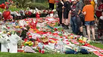 Para simpatisan meninggalkan bunga di tugu peringatan yang didirikan di dekat lapangan sepak bola Anfield untuk penyerang asal Portugal, Diogo Jota, di Liverpool, Inggris, 3 Juli 2025. (Paul BARKER/AFP)