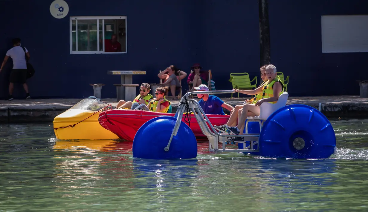 Sejumlah orang menaiki perahu kayuh di danau buatan Bassin de la Villette dalam acara Paris Plages, Paris, Prancis, 18 Juli 2020. Acara Paris Plages digelar dari 18 Juli hingga 30 Agustus, menawarkan beragam kegiatan di tepi Sungai Seine dan Bassin de la Villette. (Xinhua/Aurelien Morissard)