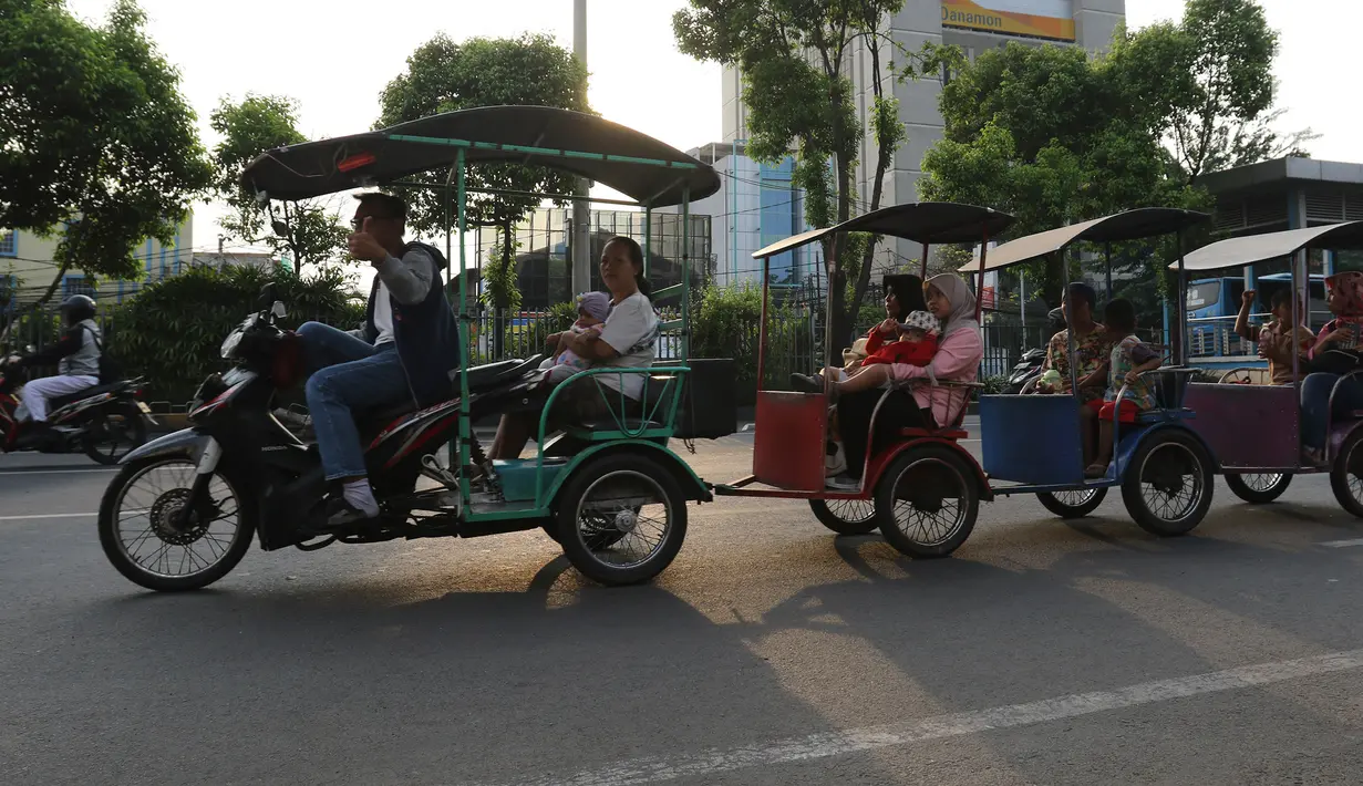 Warga menaiki Motor odong-odong melintasi kawasan Matraman, Jakarta, Rabu (23/10/2019). Dinas Perhubungan DKI Jakarta bakal menggelar operasi untuk menertibkan odong-odong yang sering dinaiki anak kecil karena alasan keselamatan. (Liputan6.com/Herman Zakharia)