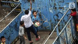 Sejumlah anak masuk ke dalam bak truk untuk bermain sepak bola, kawasan Cengkareng, Jakarta, Rabu (23/2/2022). Minimnya lahan bermain di kawasan tersebut membuat anak-anak memanfaatkan tempat yang bukan semestinya untuk bermain bola. (Liputan6.com/Johan Tallo)