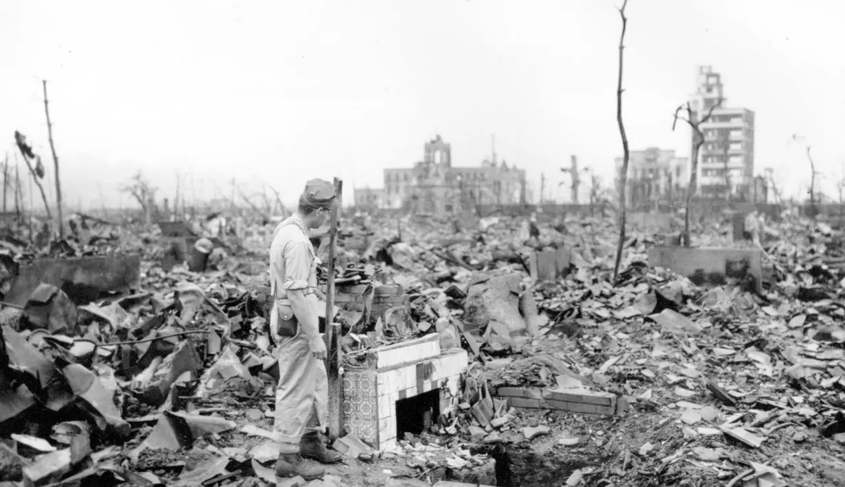 file foto 7 September 1945 ini, seorang pria tak dikenal berdiri di samping perapian berlantai tempat sebuah rumah pernah berdiri di Hiroshima, Jepang bagian barat. Pengeboman 6 Agustus 1945 adalah serangan nuklir pertama di dunia.(AP Photo/Stanley Troutman)