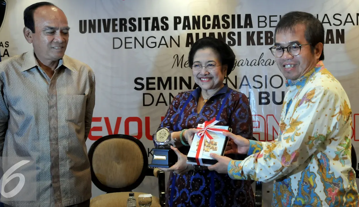 Ketua Umum PDIP Megawati Soekarnoputri menerima cinderamata dari Yudi Latif disaksikan Siswono Yudo Husodo (kiri) saat hadiri dalam seminar nasional dan bedah buku Revolusi Pancasila di Jakarta, Selasa (27/10). (Liputan6.com/Johan Tallo)