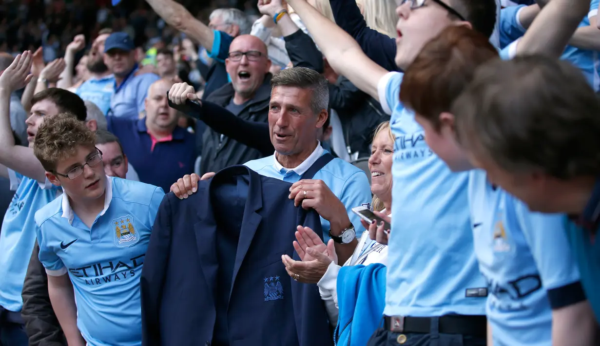 Salah satu suporter Manchester City menerima Jaket yang diberikan Pelatih Manuel Pellegrini di Stadion Liberty, Inggris (15/5). Pellegrini akan digantikan Pep Guardiola yang sebelumnya menangani Bayern Muenchen. (Reuters /Rebecca Naden)