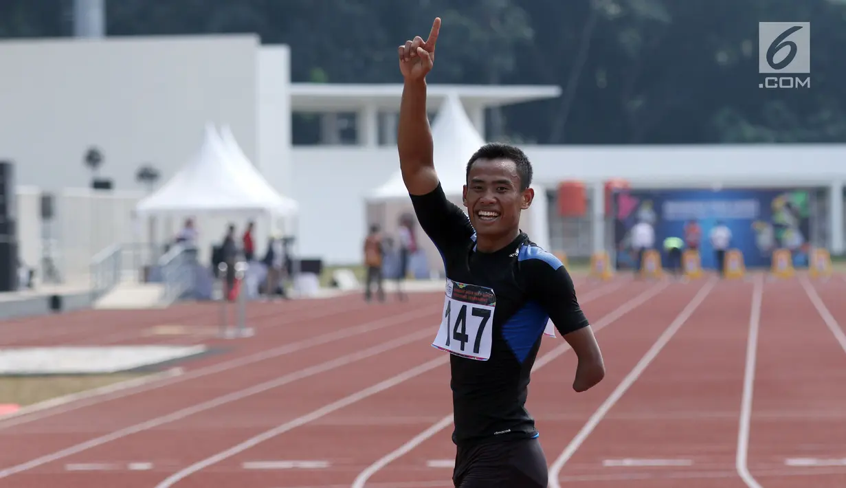 Pelari difable Indonesia, Saktyono Rizal Bagus merayakan kemenangan usai berlaga di kelas Mens 100m T45/46/47 Indonesia Para Games Invitational Tournament 2018 di Stadion Madya Senayan, Jakarta, Minggu (1/7). (Liputan6.com/Helmi Fithriansyah)