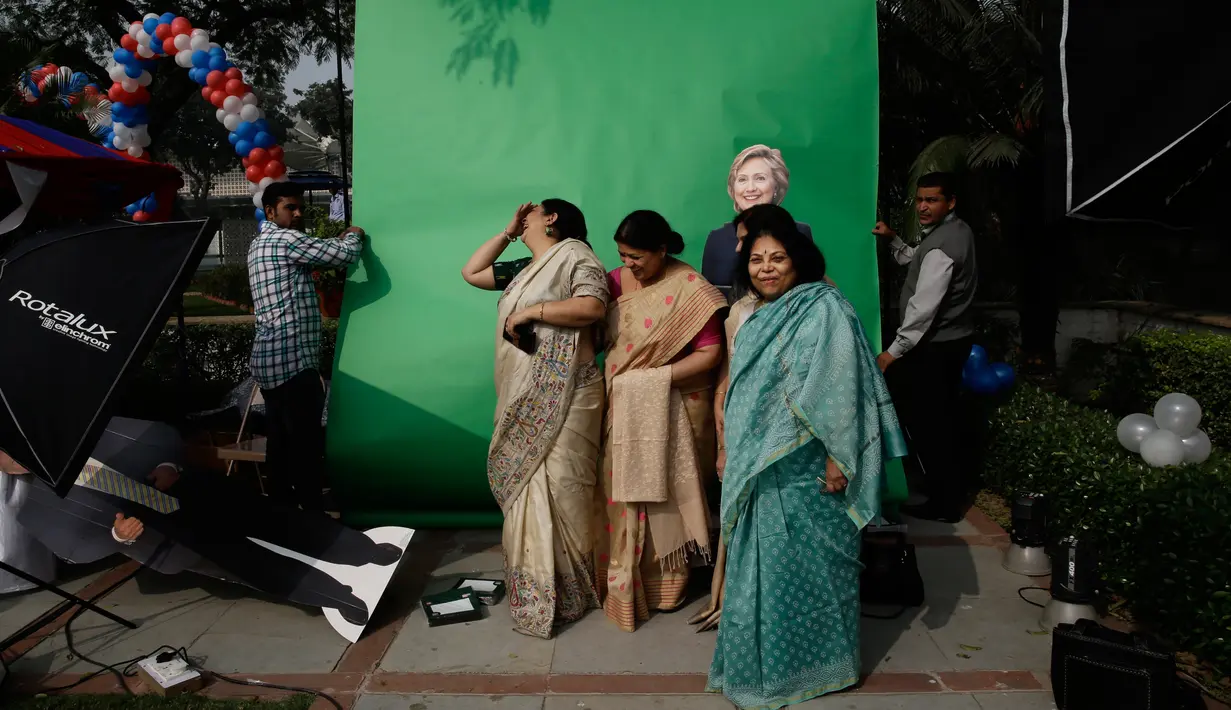 Warga India hendak berpose dengan kardus bergambar calon presiden AS di India, Rabu (9/11). (AP Photo / Saurabh Das)