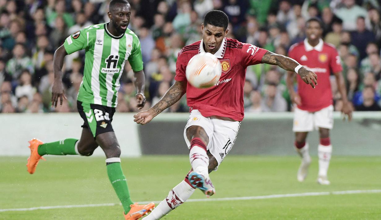 Pemain Manchester United, Marcus Rashford, melepaskan tendangan saat melawan Real Betis pada leg kedua babak 16 besar Liga Europa di Stadion Benito Villamarin, Jumat (17/3/2023). Manchester United melangkah dengan tegas ke perempat final atau 8 besar Liga Europa 2022-2023. (AFP/Cristina Quicler)
