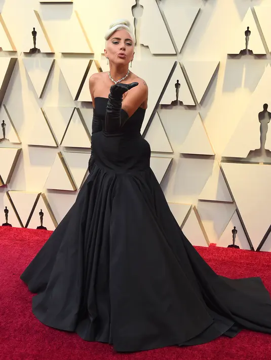 Penyanyi dan aktris Lady Gaga berpose setibanya di karpet merah Oscar 2019 di Dolby Theatre, Los Angeles, Minggu (24/2). Lady Gaga mengenakan gaun hitam koleksi Alexander McQueen dan melengkapinya dengan sarung tangan opera. (Jordan Strauss/Invision/AP)