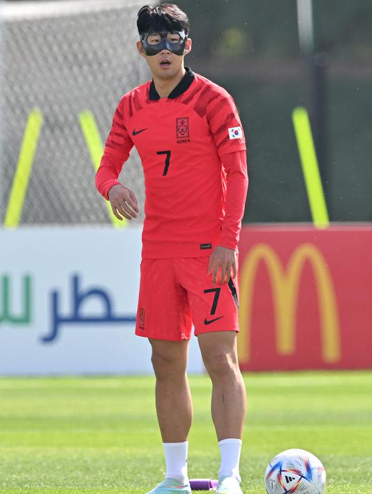 Kapten timnas Korea Selatan Son Heung-min mengenakan masker pelindung saat mengikuti sesi latihan menjelang dimulainya Piala Dunia 2022 Qatar, di Al Egla Training Site 5 di Doha, Rabu (16/11/2022). Seperti diketahui Son Heung-min menderita patah rongga mata saat membantu Tottenham Hotspur mengalahkan Marseille di Liga Champions. (Jung Yeon-je / AFP)