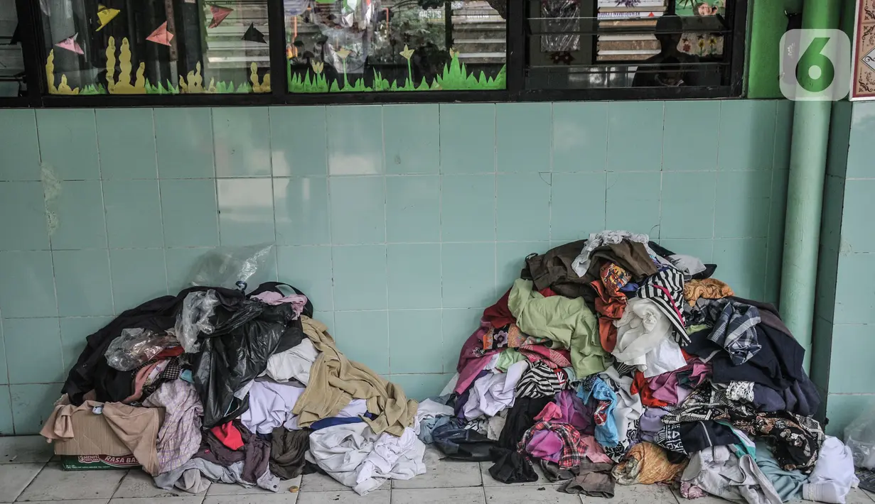 Tumpukkan pakaian hasil sumbangan di depan ruang kelas di SDN 09 Kebon Kosong, Kemayoran, Jakarta, Selasa (31/8/2021). Sebanyak 250 warga masih mengungsi di gedung sekolah pasca kebakaran menghanguskan puluhan rumah semipermanen di RT 14/RW 05 pada Minggu (29/8). (merdeka.com/Iqbal S. Nugroho)