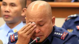 Kepala Polisi Nasional Filipina Ronald Dela Rosa menyeka air matanya disela sidang dengar pendapat di Manila, Rabu (23/11). Tangisan itu muncul setelah mendengar kesaksian tentang keterlibatan polisi dalam peredaran narkoba. (REUTERS/Romeo Ranoco)