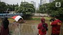 Warga menyaksikan pembentangan bendera Merah Putih di aliran kali
Ciliwung di kawasan Sudirman, Jakarta, Minggu (22/8/2021). Pembentangan atau pengibaran bendera Merah Putih tersebut dilaksanakan untuk memperingati HUT ke-76 RI. (Liputan6.com/Faizal Fanani)