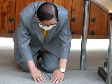 Pemimpin sekte Gereja Shincheonji Yesus, Lee Man-hee berlutut dan membungkuk untuk meminta maaf kepada publik saat konferensi pers di Gapyeong, Senin (2/3/2020). Pemimpin sekte tersebut meminta maaf karena jemaatnya menjadi penyebab penyebaran wabah virus corona di Korea Selatan. (POOL/AFP)