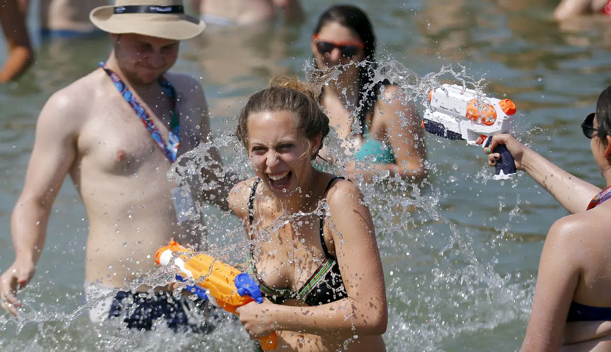Sejumlah peserta asik bermain air di sungai Danube selama festival musik Sziget, Budapest , Hongaria, Rabu (12/8/ 2015). Festival ini diselenggarakan karena suhu panas yang melanda Hongaria dengan suhu hingga 38 derajat. (REUTERS/Laszlo Balogh)