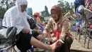 Pembina anggota Kwarnas Gerakan Pramuka menangis sambil membasuh kaki ibunya di Taman Wiladatika Cibubur, Jakarta, Rabu (21/12). Aksi massal membasuh kaki ibu itu dalam rangka memperingati Hari Ibu 2016. (Liputan6.com/Yoppy Renato)
