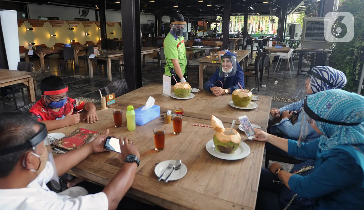 Pelayan mengenakan pelindung wajah saat melayani pengunjung di Restoran Bandar Djakarta, Alam Sutra, Tangerang Selatan, Banten, Rabu (10/6/2020). Tangerang dan Tangerang Selatan menjalankan PSBB transisi menuju kenormalan baru dengan menerapkan protokol kesehatan COVID-19. (merdeka.com/Arie Basuki)
