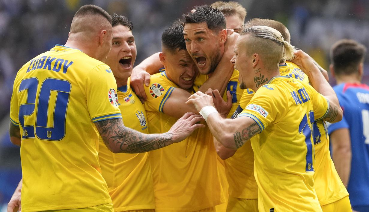 Timnas Ukraina membuka peluang maju ke babak 16 besar Euro 2024 setelah pada matchday kedua Grup E sukses menaklukkan Slovakia 2-1 di Merkur Spiel-Arena, Dusseldorf, Jerman, Jumat (21/6/2024) malam WIB. Sempat tertinggal sejak menit ke-17 lewat gol Ivan Schranz, Ukraina melakukan comeback dengan mencetak dua gol pada babak kedua melalui Mykola Shaparenko (54') dan Roman Yaremchuk (80'). Mengemas tiga poin, Ukraina naik ke posisi kedua Grup E di bawah Rumania yang unggul selisih gol dan baru memainkan satu laga. (AP Photo/Andreea Alexandru)