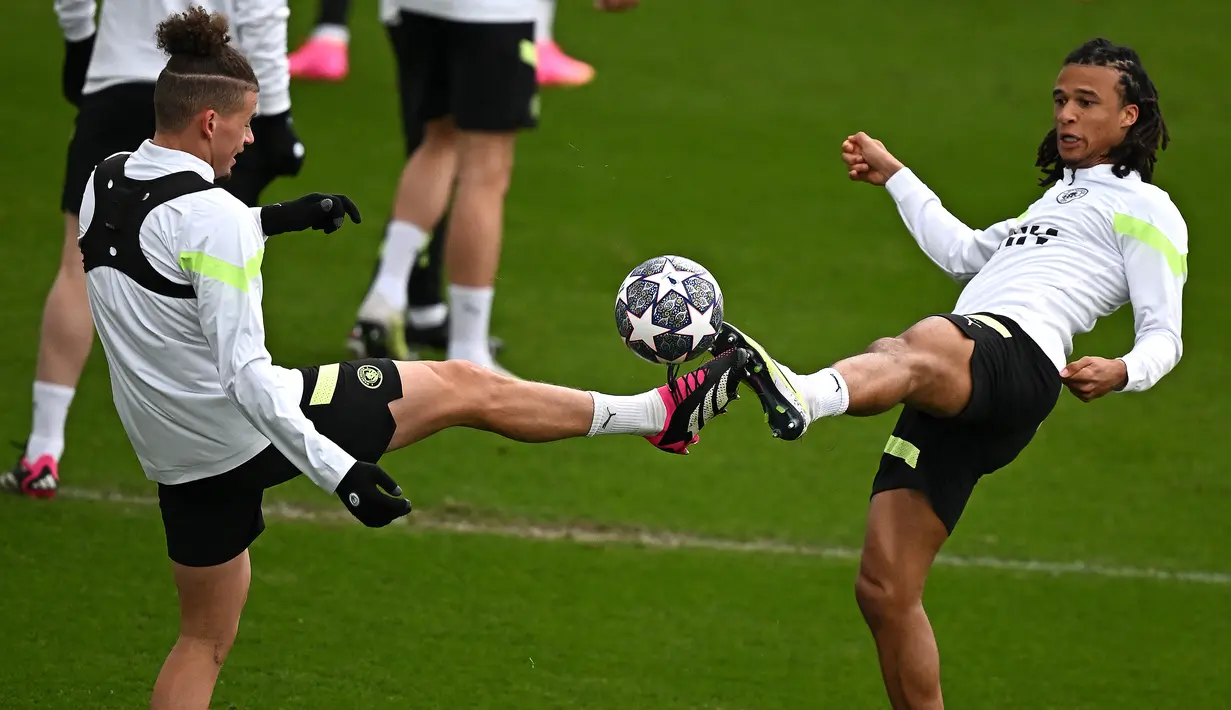 Gelandang Manchester City Kalvin Phillips (kiri) dan bek Manchester City Nathan Ake menghadiri sesi latihan tim menjelang leg pertama perempat final Liga Champions melawan Bayern Munchen, di tempat latihan Manchester City di Manchester, Senin (10/4/2023). (Photo by Paul ELLIS / AFP)