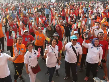 Warga mengangkat tumbler saat mengikuti gerakan 1 juta  tumbler di GBK, Senayan, Jakarta, Minggu (28/7/2019). Gerakan 1 juta  tumbler dicanangkan untuk indonesia tanpa plastik. (Liputan6.com/Angga Yuniar)