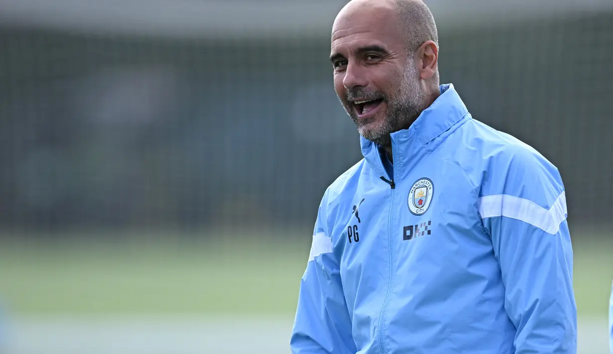 Pelatih Manchester City, Pep Guardiola bereaksi saat memimpin sesi latihan di City Football Academy, di Manchester, Inggris (5/9/2022). Manchester City akan bertanding melawan Sevilla pada Grup G Liga Champions di Estadio R. Sanchez Pizjuan. (AFP/Oli Scarff)