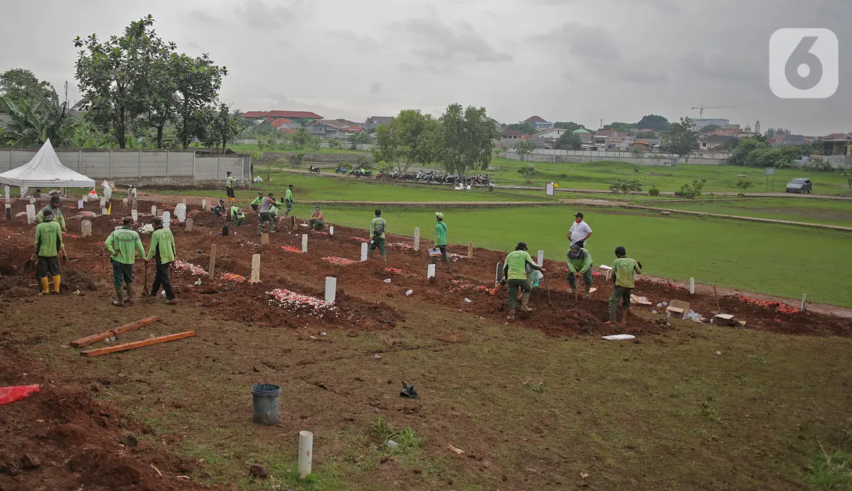 Petugas dengan APD melakukan proses pemakaman dengan protokol Covid-19 di TPU Bambu apus, Jakarta Timur, Minggu (24/1/2021). Empat hari dibuka, 126 jenazah telah dikebumikan dengan protap Covid-19 di TPU Bambu Apus, Cipayung, Jakarta Timur. (Liputan6.com/Herman Zakharia)