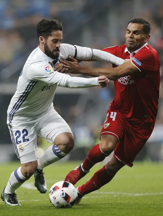Gelandang Real Madrid, Isco, berusaha melewati bek Sevilla, Gabriel Mercado. Pada laga ini Los Blancos tampil tanpa pemain andalannya trio BBC (Bale, Benzema, Cristiano Ronaldo). (AP/Stringer)