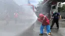 Petugas Pertamina dan Damkar melakukan penyemprotan disinfetaktan di SPBU depan RS Azra, Bogor, Jawa Barat, Jumat (27/03/2020). Hari ini seluruh SPBU di wilayah Bogor dilakukan penyemprotan disinfektan dalam rangka mencegah penyebaran wabah Covid-19. (merdeka.com/Arie Basuki)