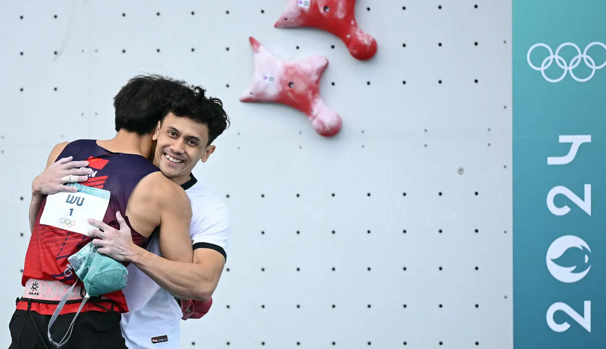 Atlet panjat tebing Indonesia, Veddriq Leonardo (kanan) berpelukan dengan wakil China, Wu Peng setelah memastikan kemenangan pada cabang olahraga pajat tebing nomor speed Olimpiade Paris 2024 di Le Bourget Sport Climbing Venue, Paris, Prancis, Kamis (08/08/2024). (AFP/Jonathan Nackstrand)