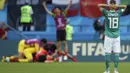 Joshua Kimmich terpaku melihat para pemain Korea Selatan merayakan gol Son Heung-min pada laga grup F Piala Dunia 2018 di Kazan Arena, Kazan, Rusia, (27/6/2018). Kekalahan tersebut membuat Jerman gagal melju ke babak 16 besar. (AP/Thanassis Stavrakis)