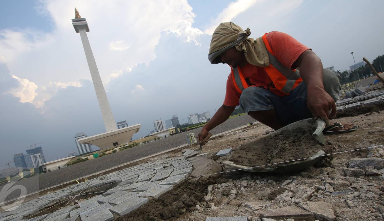 Seorang pekerja menyelesaikan pelataran yang rusak di kawasan Monas, Jakarta, Kamis (10/11). Hal tersebut dilakukan untuk menjaga kawasan Monas agar tetap terawat dan nyaman bagi pengunjung. (Liputan6.com/Immanuel Antonius)