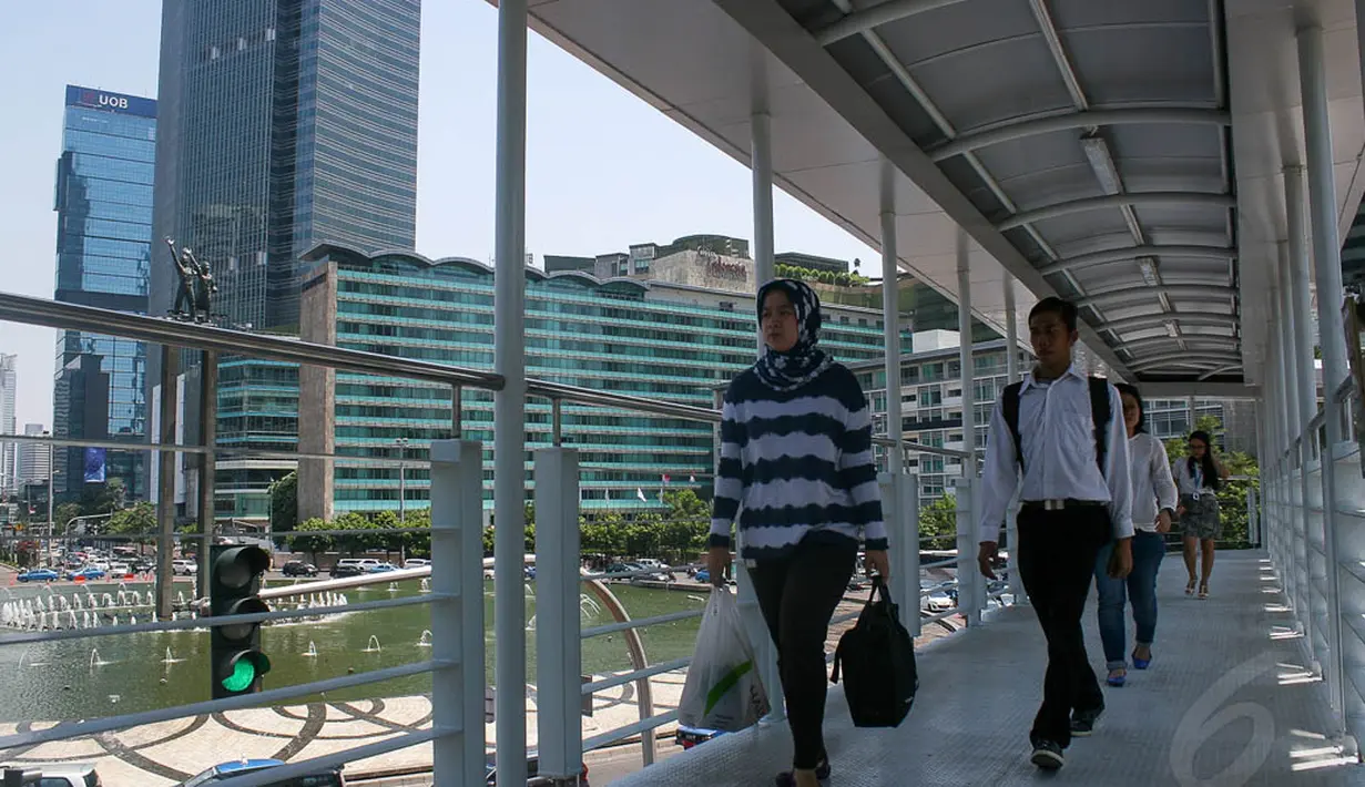 Beberapa pejalan kaki sudah berlalu lalang di JPO baru di Bundaran HI, Jakarta, (24/9/14). (Liputan6.com/Faizal Fanani)