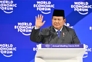 Hal itu dipaparkan Presiden Prabowo saat berpidato pada pertemuan tahunan Forum Ekonomi Dunia (WEF) di Davos, Swiss, pada Kamis 22 Januari 2026. Tampak dalam foto, Presiden Indonesia, Prabowo Subianto mengangkat tangan saat menyampaikan pidato khusus (special address) pada pertemuan tahunan Forum Ekonomi Dunia (WEF) di Davos, Swiss, pada Kamis 22 Januari 2026. (Fabrice COFFRINI/AFP)