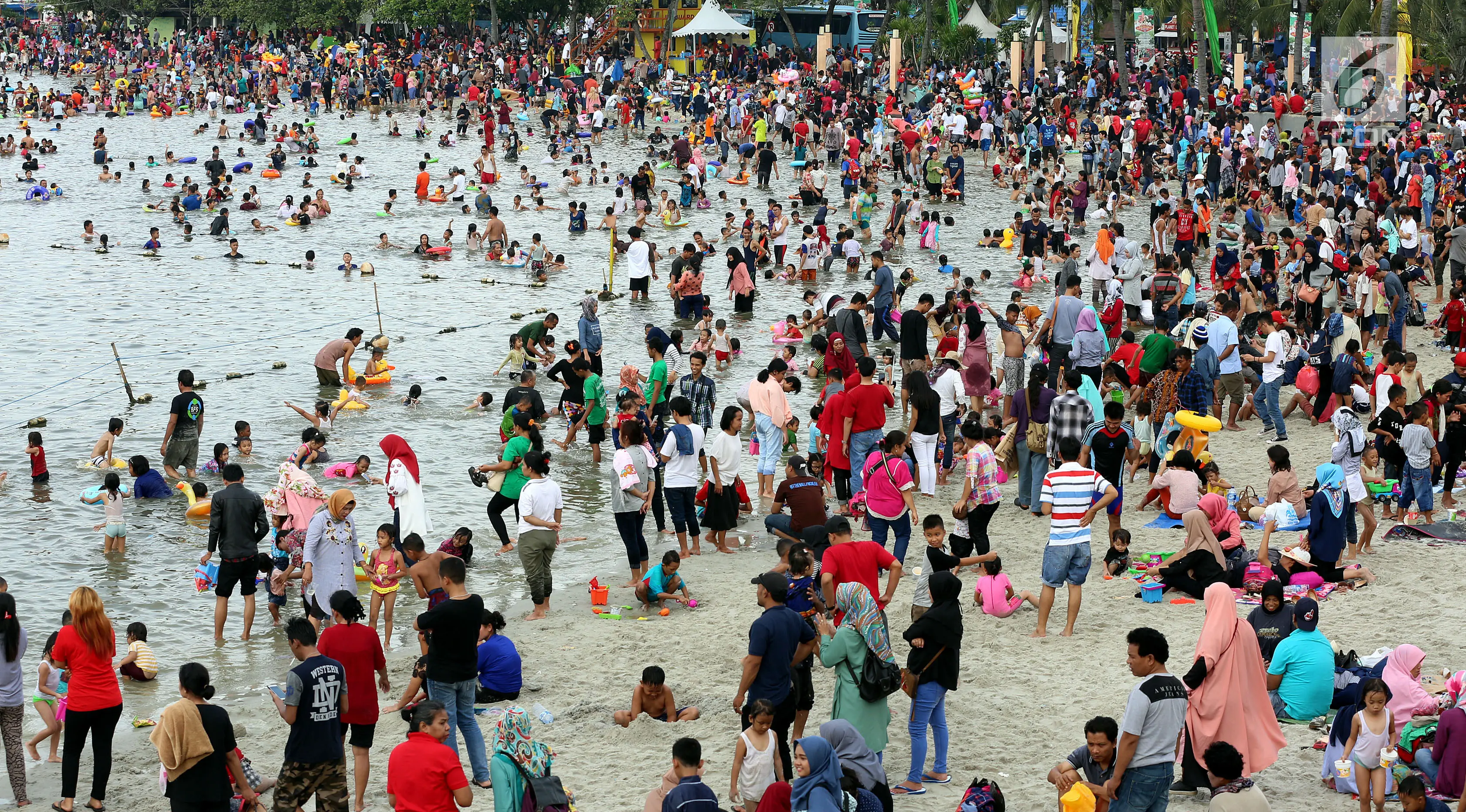 Warga memadati Pantai Ancol, Jakarta, Senin (26/6). Memasuki hari kedua lebaran Warga DKI Jakarta memanfaatkan liburnya bersama keluarga bertamasya ke tempat-tempat wisata Favorit mereka yang ada di Jakarta kususnya Ancol. (Liputan6.com/Johan Tallo)