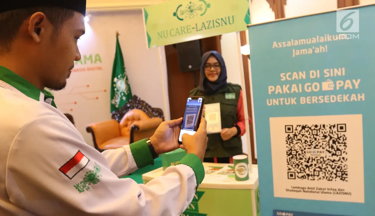 Model mencoba QR Code melalui dompet digital Go-Pay saat peluncuran kerja sama strategis pemberdayaan ekonomi umat berbasis digital di Jakarta (16/7/2019). Gojek, Go-Pay, dan NU Care-LazisNU menjalin kerja sama untuk pembayaran zakat, infaq, dan sedekah secara nontunai. (Liputan6.com/Angga Yuniar)
